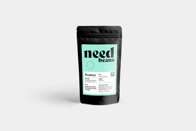 Black coffee packaging with 'need beans' branding on a light gray background