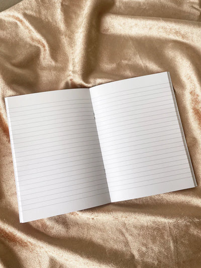 Open notebook with lined pages on a textured beige surface