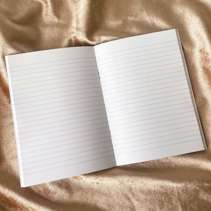 Open notebook with lined pages on a textured beige fabric background