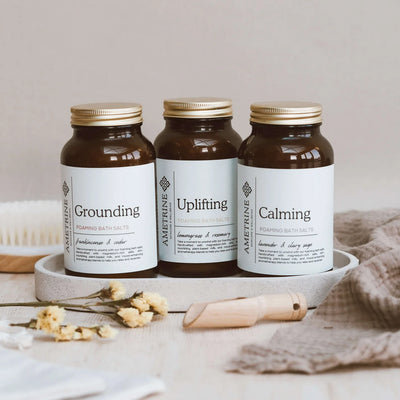 Three jars of Aventine bath salts labeled 'Grounding', 'Uplifting', and 'Calming' on a neutral background.