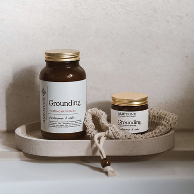 Two jars labeled 'Grounding' on a stone tray with a neutral background