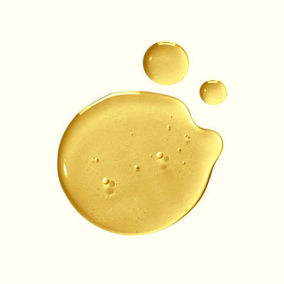 Gold-colored liquid droplets on a white background