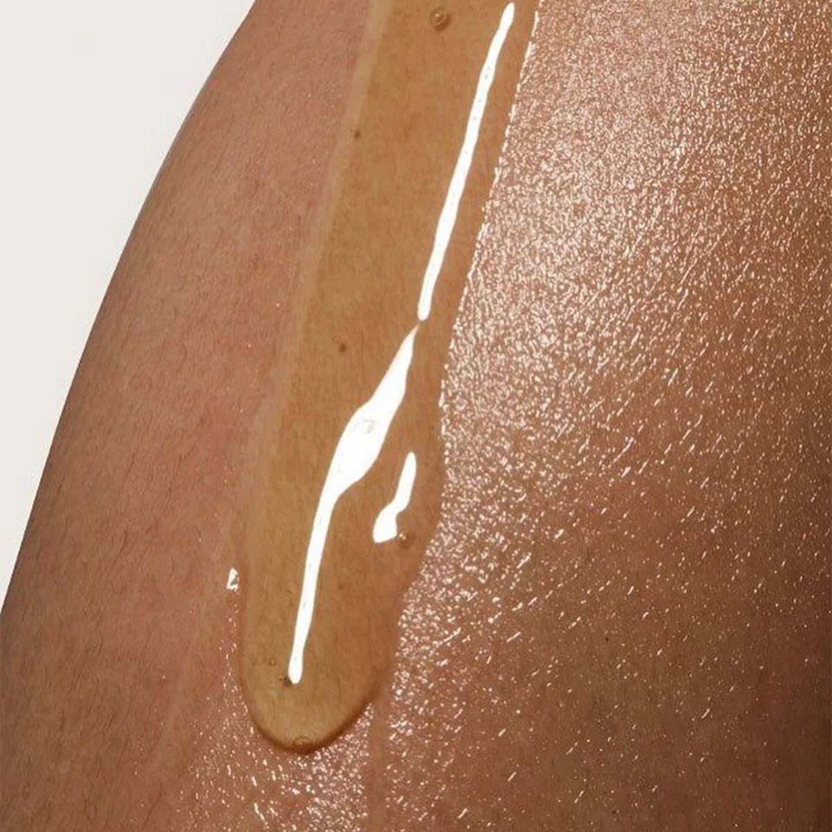 Close-up of a brown liquid droplet on skin texture