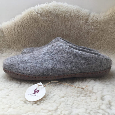 Gray slipper with a brand tag on a soft, beige surface