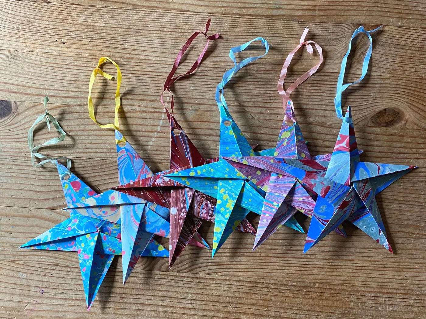 Colorful paper star ornaments on a wooden surface