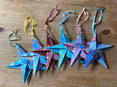 Colorful paper star ornaments on a wooden surface