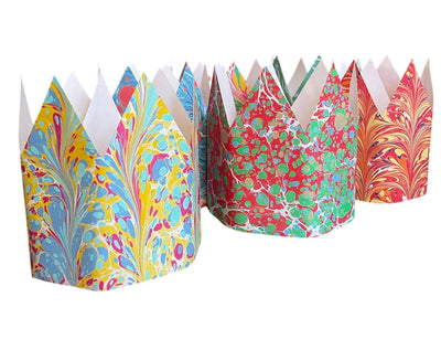 Colorful paper cupcake liners with marbled patterns on a white background