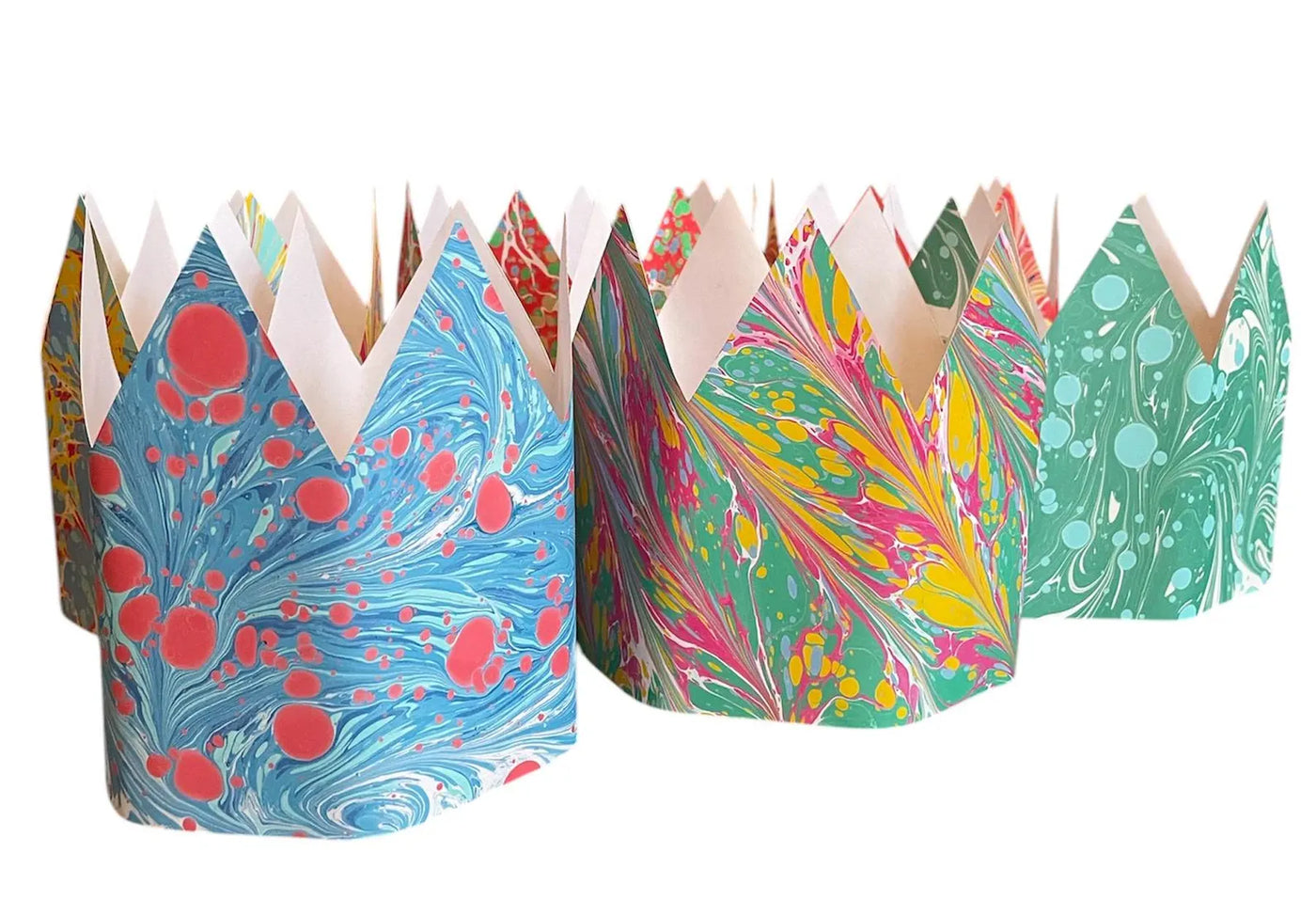 Colorful paper crowns with marbled patterns on a white background