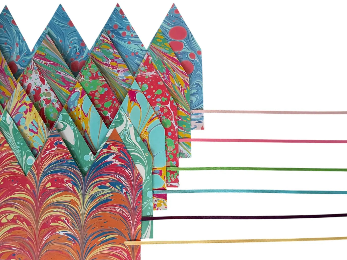 Colorful marbled paper sheets with wooden sticks on a white background