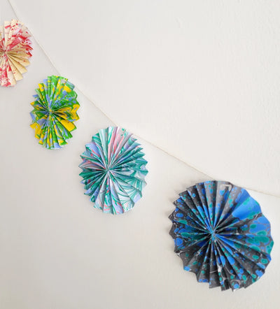 Colorful paper fan decorations on a white surface