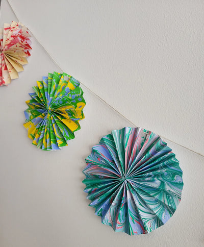 Colorful paper rosettes on a white surface