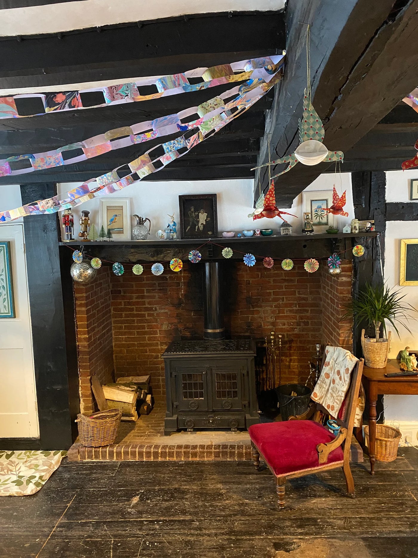 Living room with a fireplace, red chair, and decorative elements.