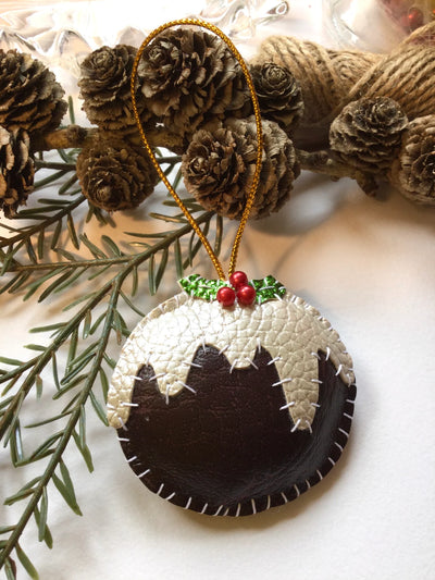 Christmas pudding ornament with holly on a decorative background