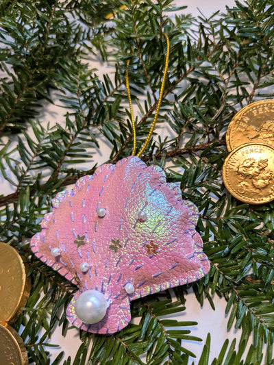 Iridescent shell ornament with pearls on a Christmas tree with gold coins.