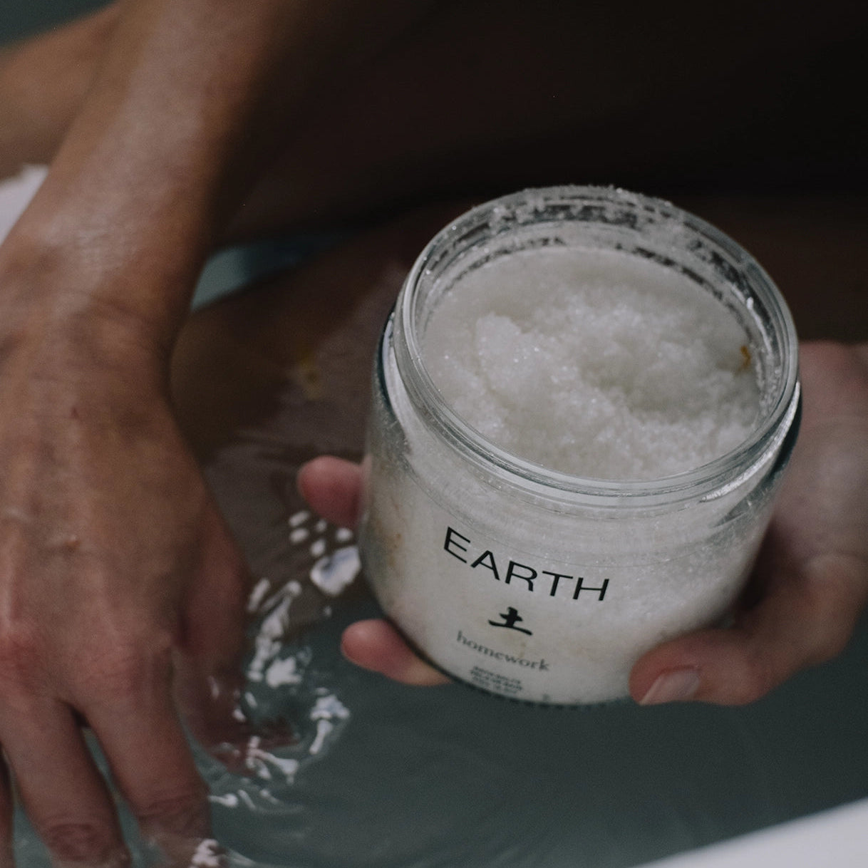 Person holding a jar labeled 'Earth' with a textured surface.
