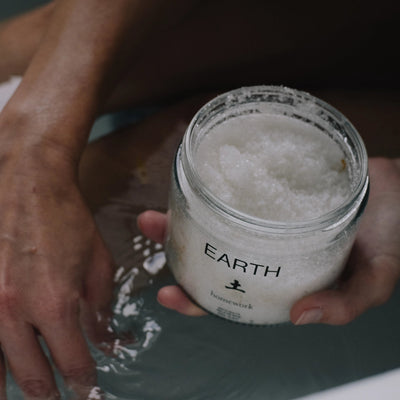 Person holding a jar labeled 'Earth' with a textured surface.