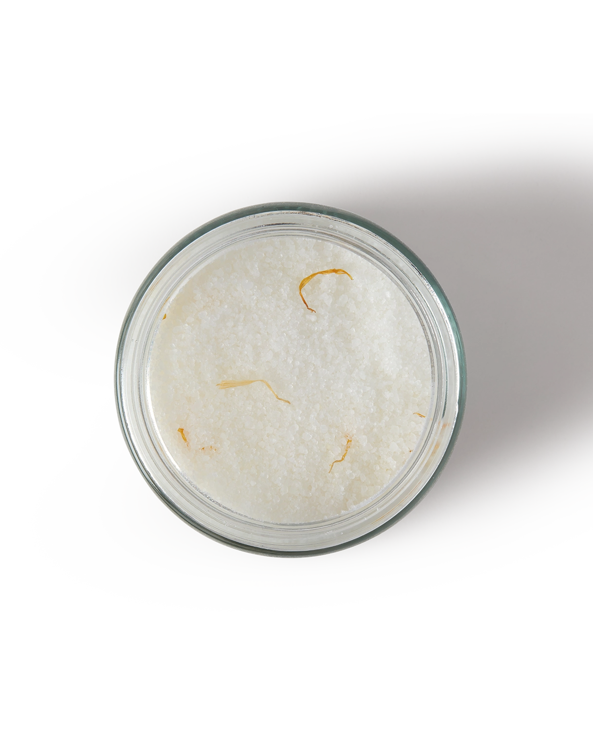 Glass container with a white powdery substance and yellowish fibers on a white background