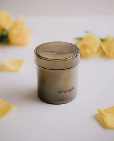 Gray container labeled 'homework' on a light surface with yellow flowers.