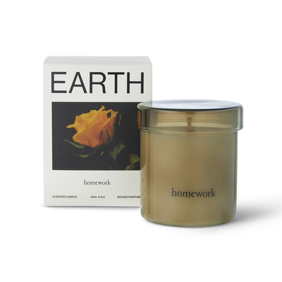 Candle labeled 'homework' with packaging featuring an orange flower and the word 'EARTH'.