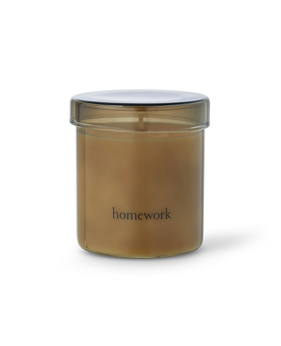 Gold-colored candle jar with 'homework' text on a white background