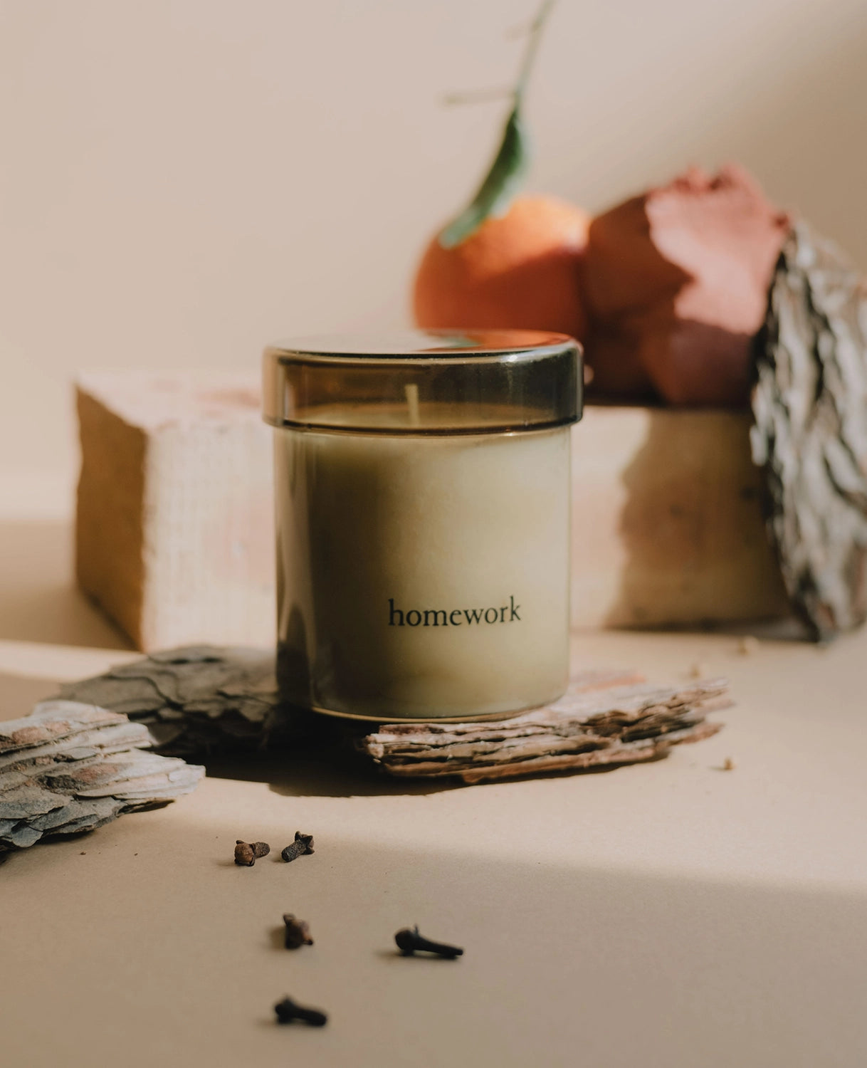 Candle labeled 'homework' on a surface with decorative elements