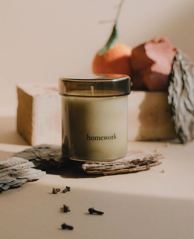 Candle labeled 'homework' on a surface with decorative elements