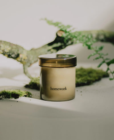 Candle labeled 'homework' with a natural background