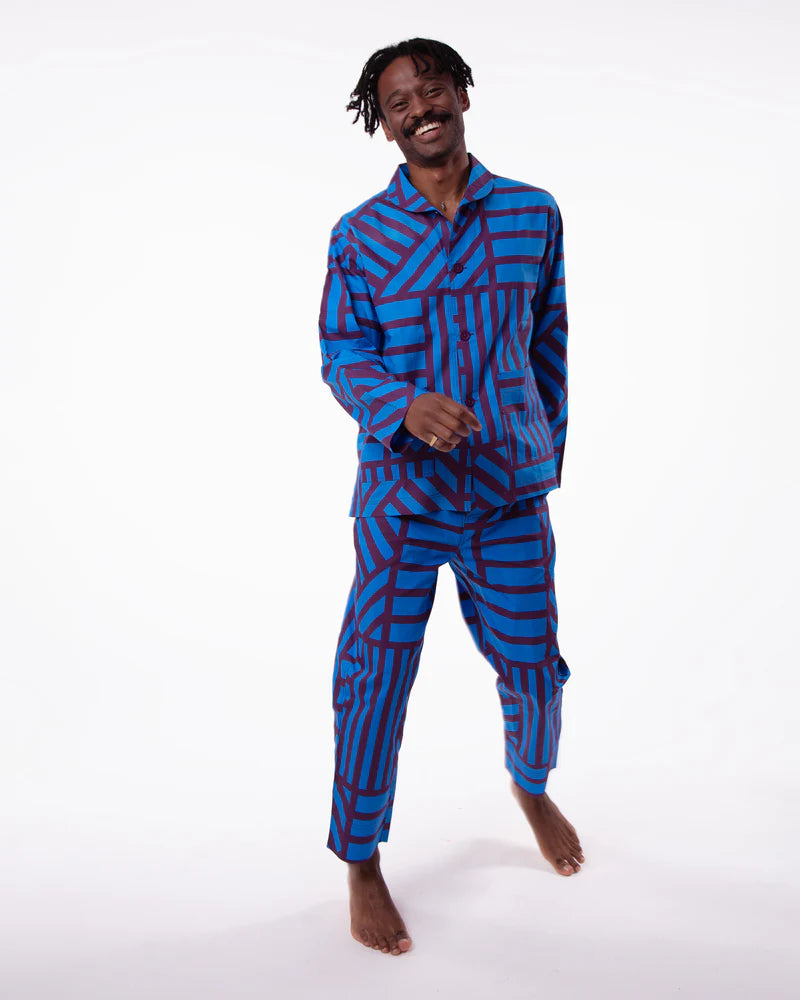 Person wearing a blue and red patterned pajama set on a white background