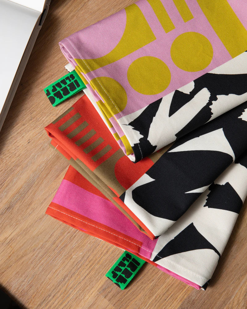 Colorful fabric tea towels on a wooden surface