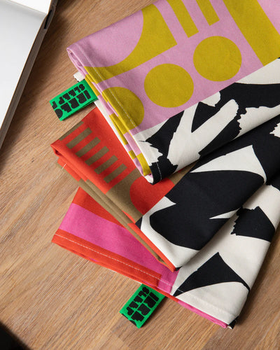 Colorful fabric tea towels on a wooden surface