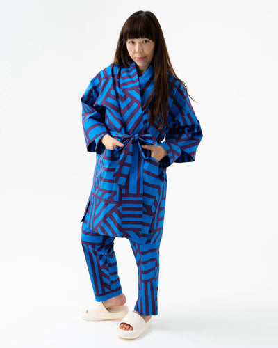 Child wearing a blue geometric patterned outfit on a white background