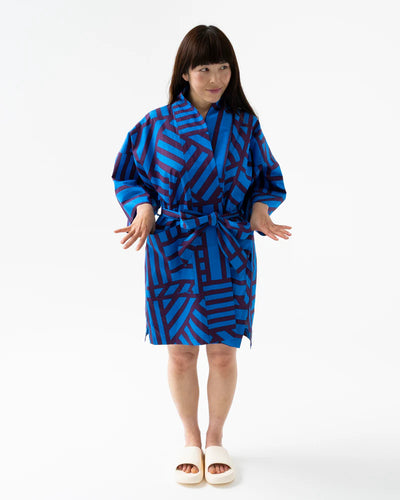 Woman wearing a blue patterned robe on a white background