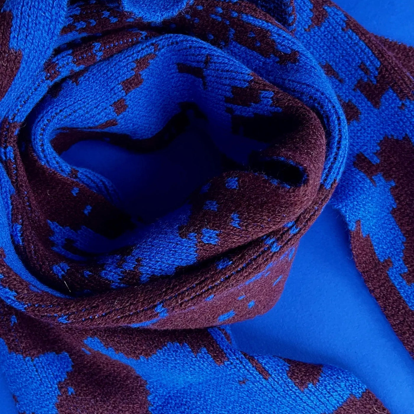 Close-up of a blue and brown patterned fabric roll on a blue background