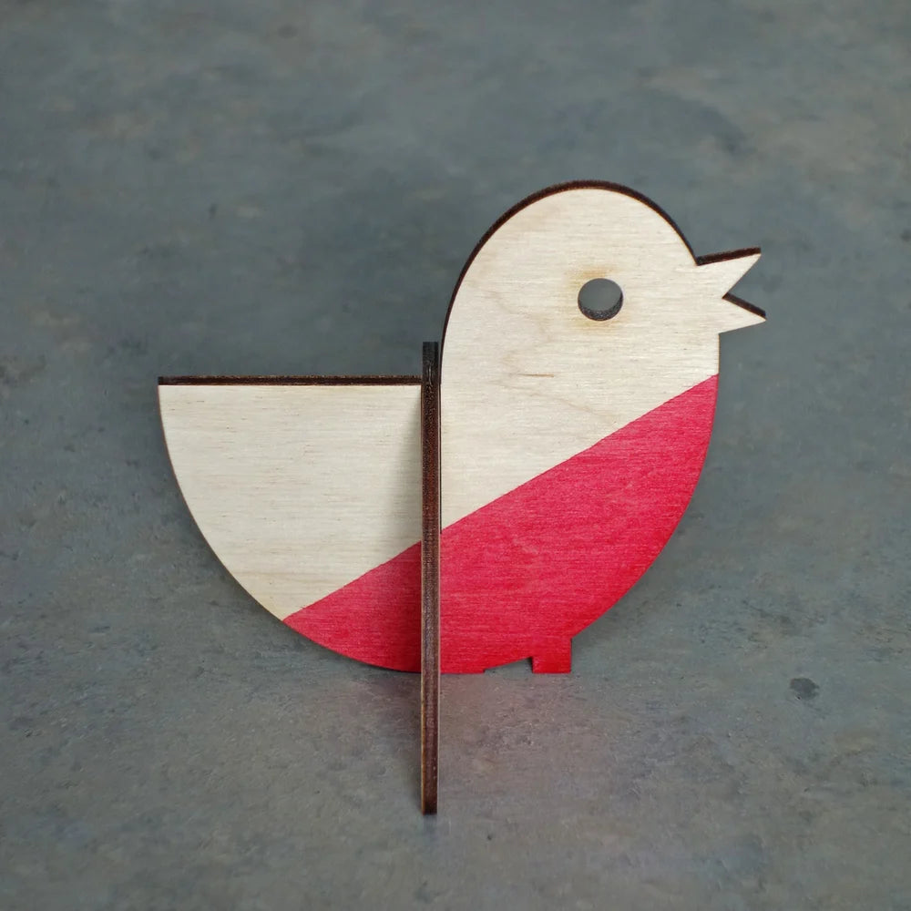 Wooden bird ornament with red and white design on a gray background