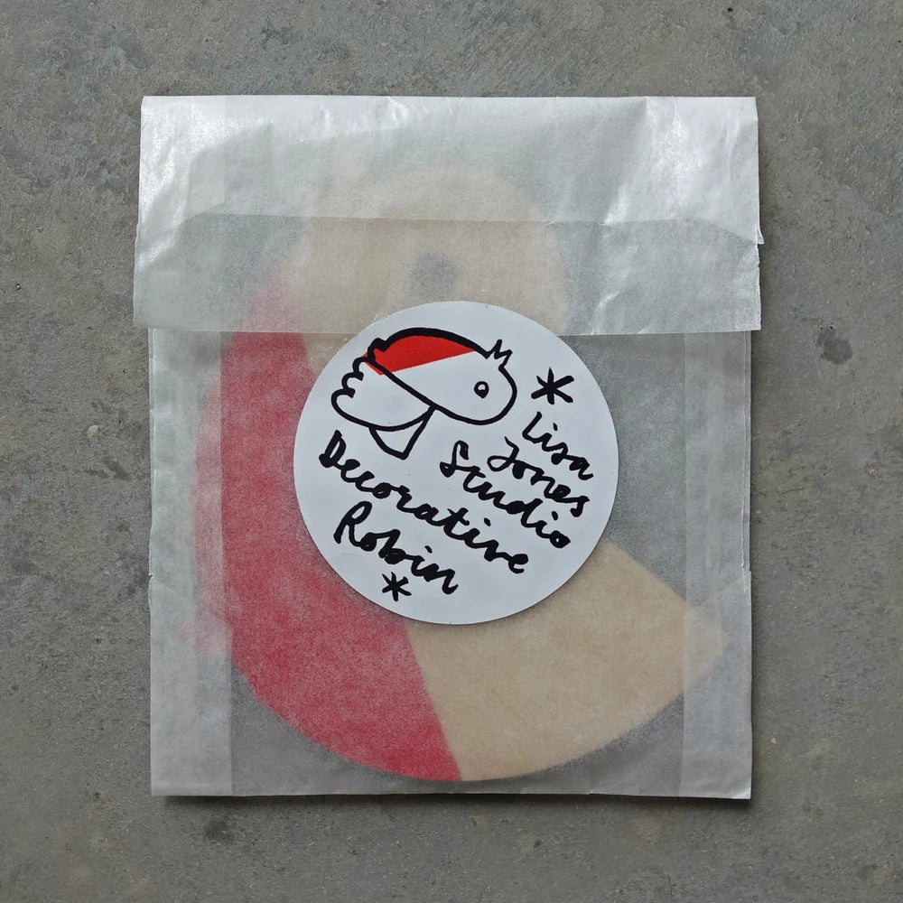 Round sticker with 'Lion Jones Studio' text on a transparent bag against a gray background