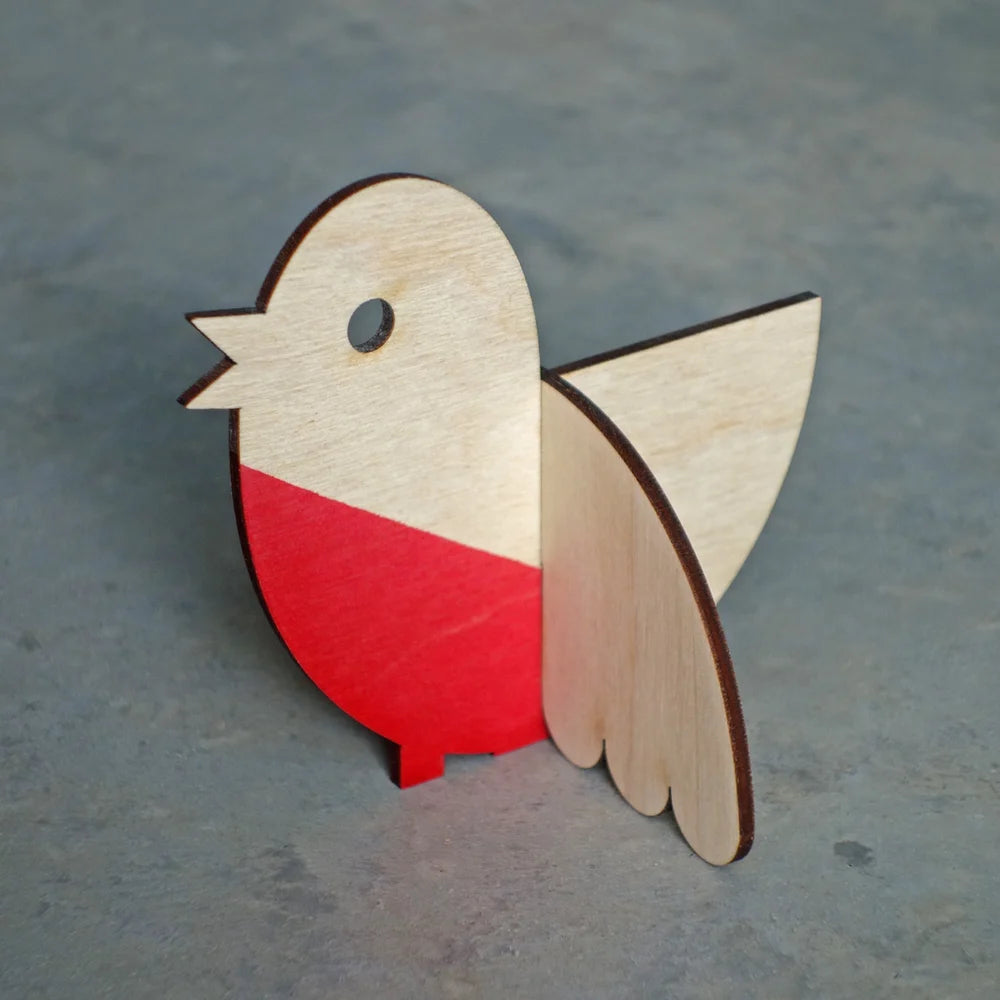 Wooden bird ornament with red chest on a gray surface