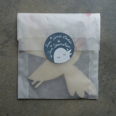 Bird-shaped decoration with a label on a textured surface