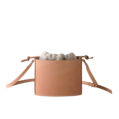 Tan leather bag with a strap on a white background