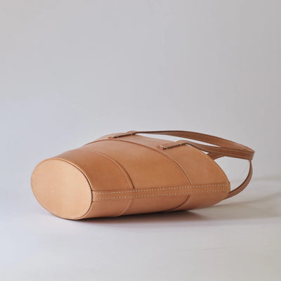 Tan leather handbag on a light gray background