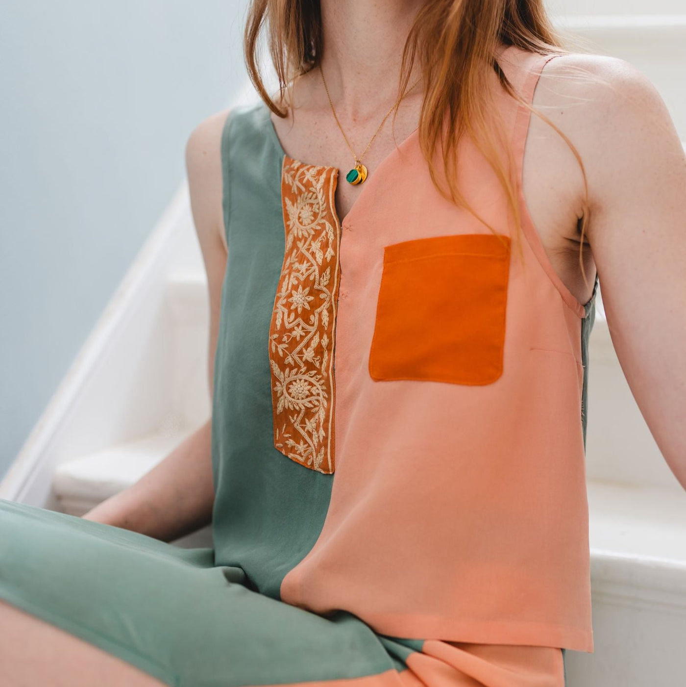 Woman wearing a colorful dress with a geometric pattern on a light background