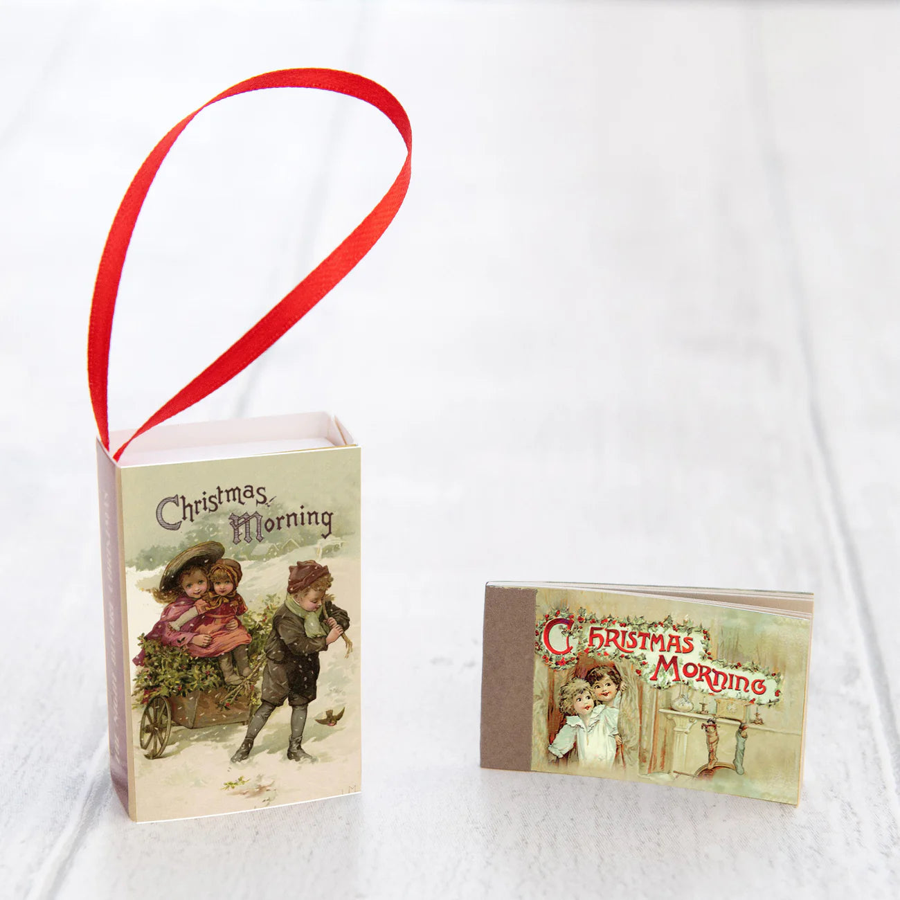 Vintage-style Christmas card with children and a red ribbon on a white background