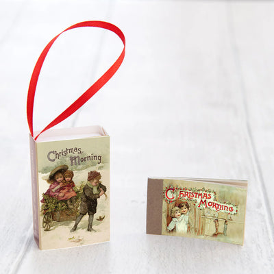 Vintage-style Christmas card with children and a red ribbon on a white background