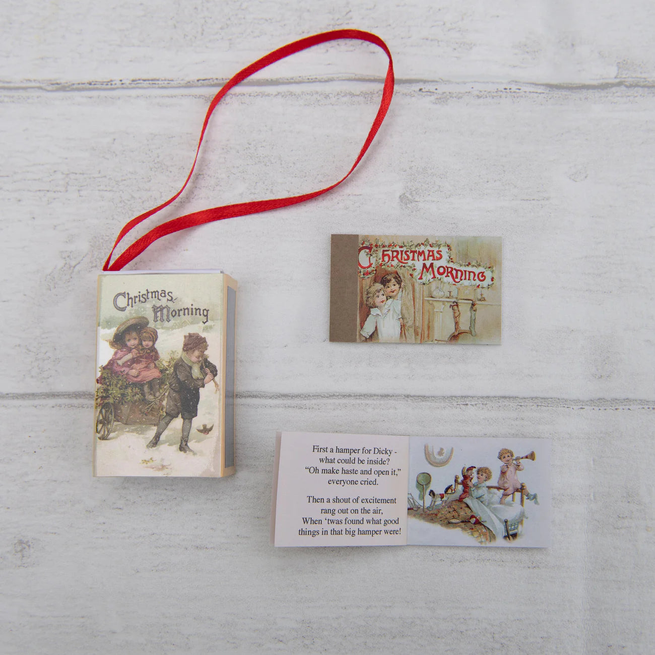 Vintage-style Christmas book with illustrations and a red ribbon on a wooden surface