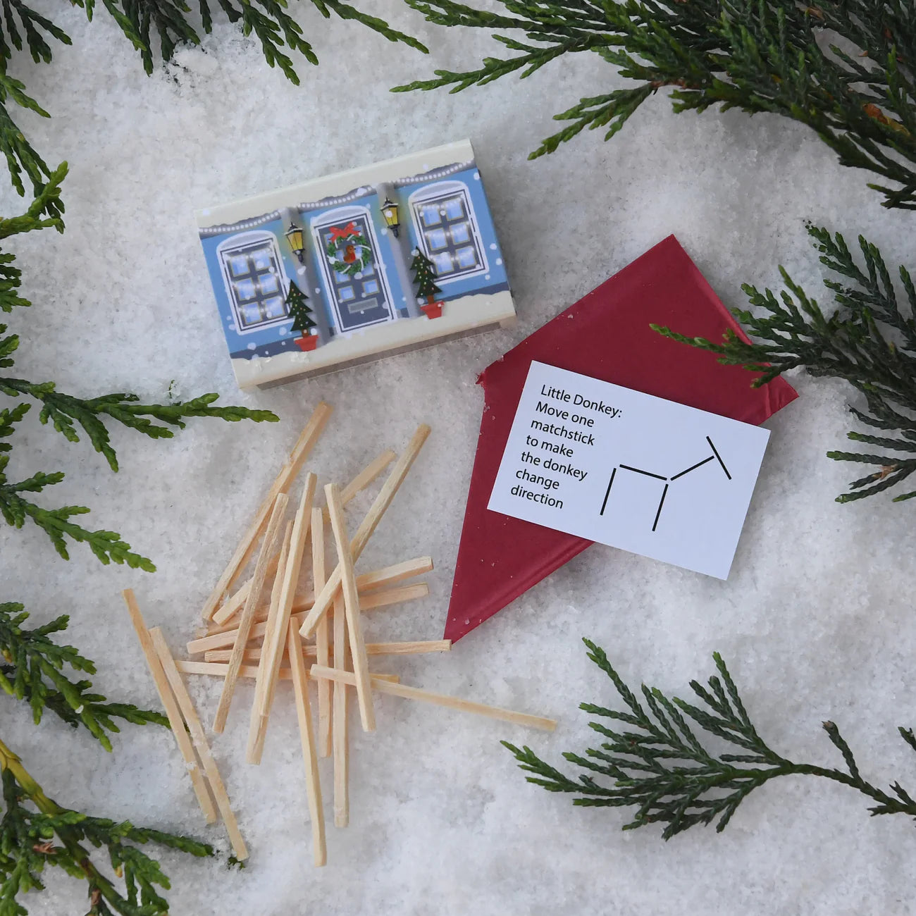 Matchstick game with matchbox and instructions on a snowy background