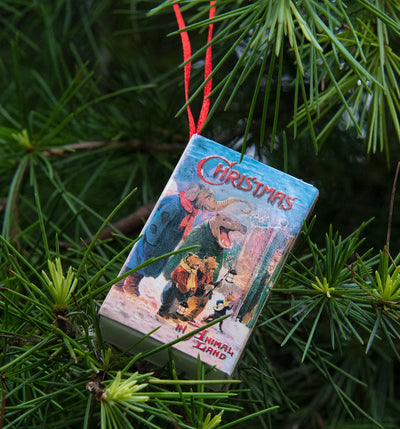 Christmas book ornament hanging on a tree branch