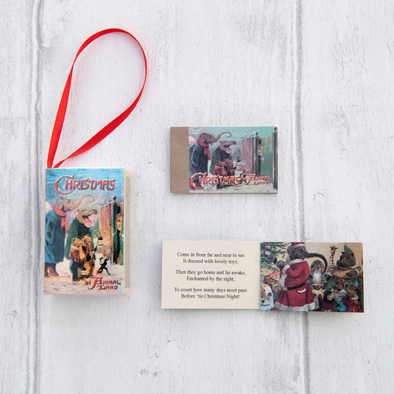 Set of Christmas-themed cards with a red ribbon on a white wooden surface