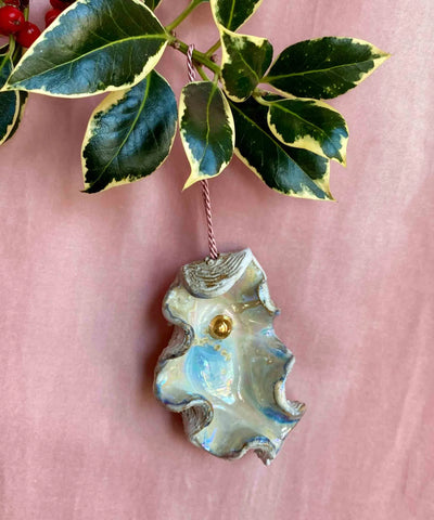 Decorative leaf ornament with gold center on a pink background