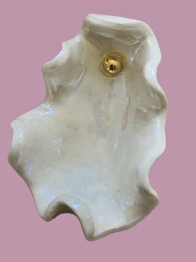 Large shell with a gold center on a pink background