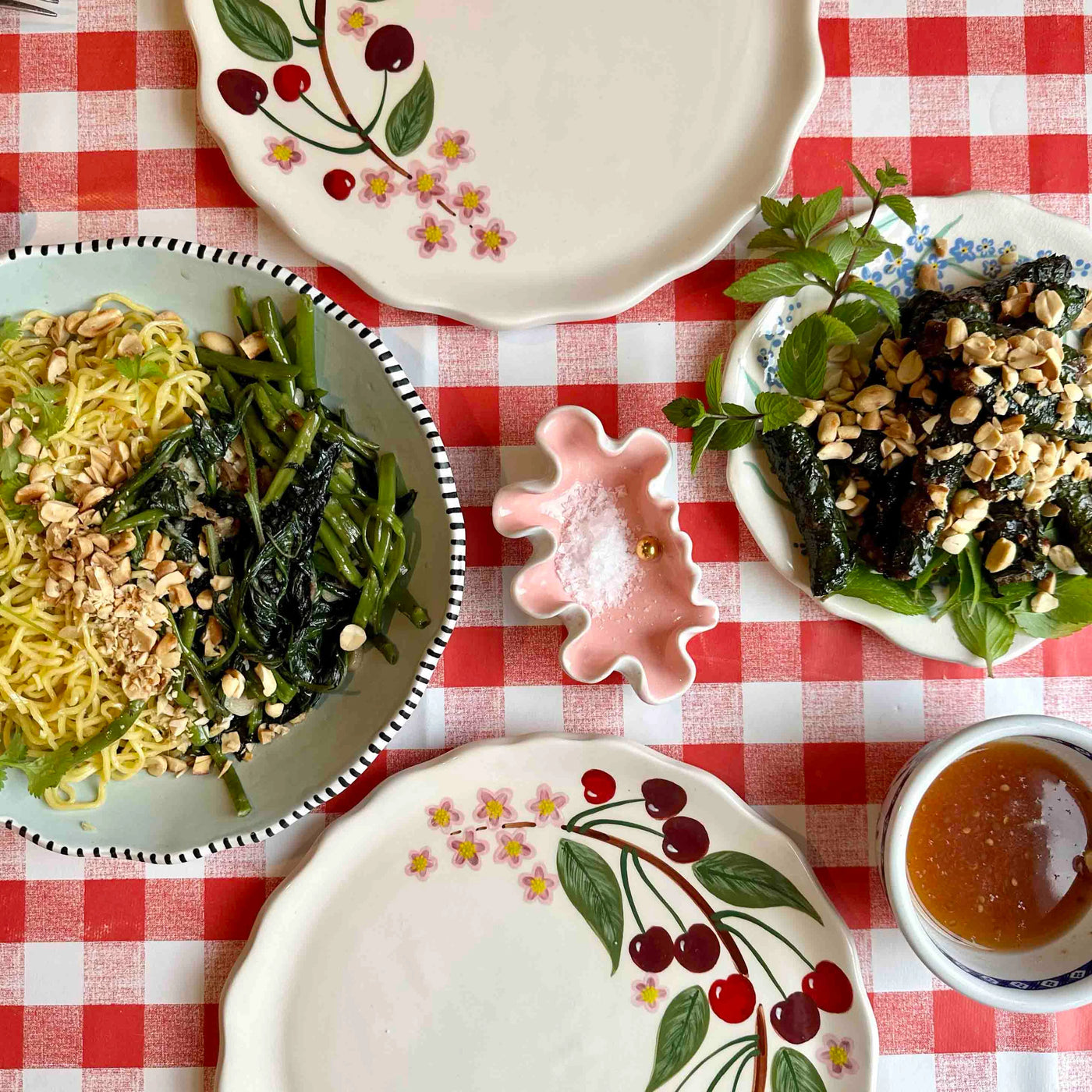 Dishes of food on a red and white checkered tablecloth