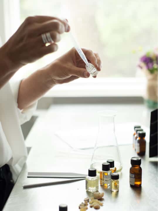 Person working with small bottles and a dropper in a laboratory setting
